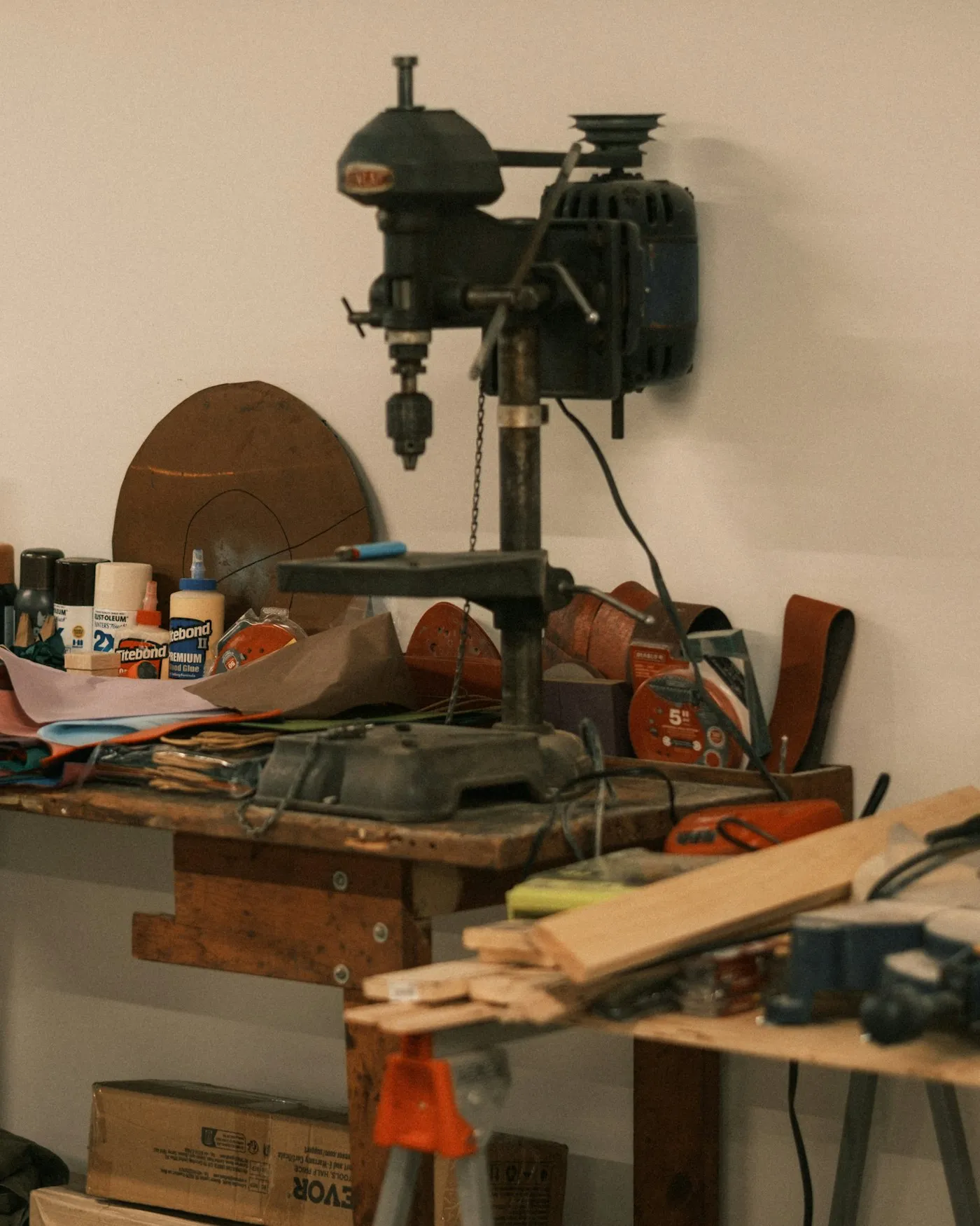 A working bench in a small workshop, tools and offcuts left where they were last used.